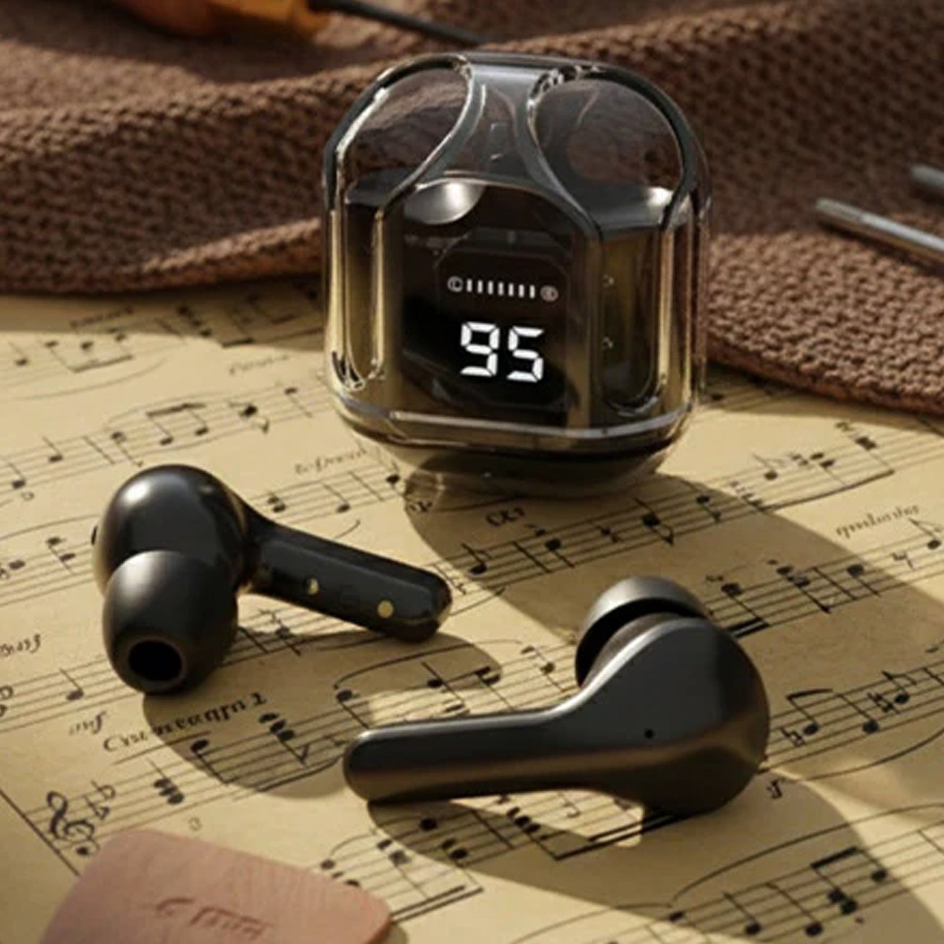 CTRL8 true wireless earbuds UB with transparent case and digital display placed on a musical sheet
