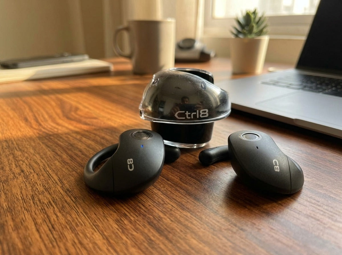 CTRL8 T2 over-the-ear earbuds placed on a wooden desk, ideal for work or casual use.