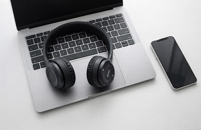CTRL8 dual-mode wireless headphones with mic placed on a laptop, ideal for work and entertainment